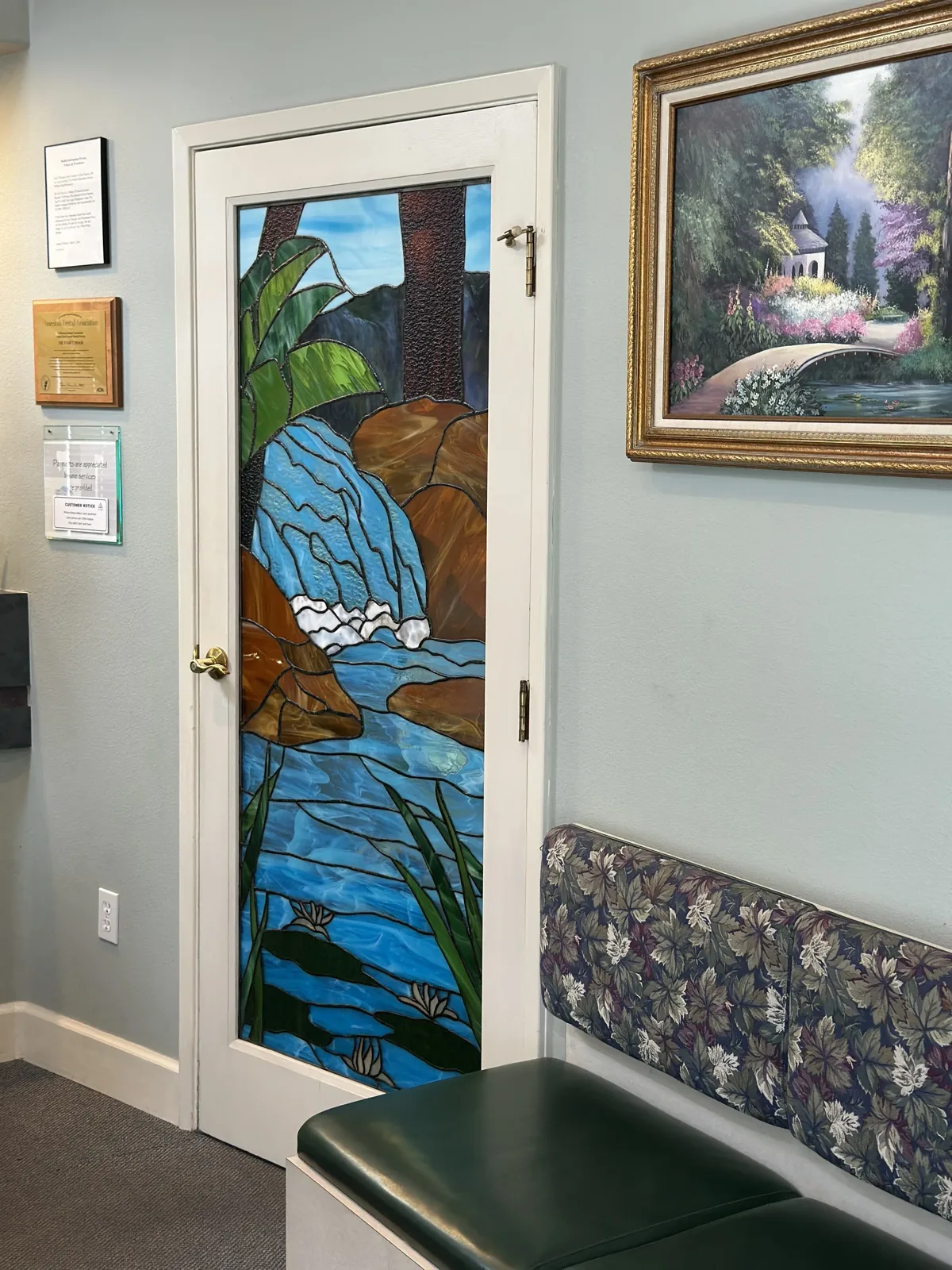 Stained glass door and waiting area with landscape paintings
